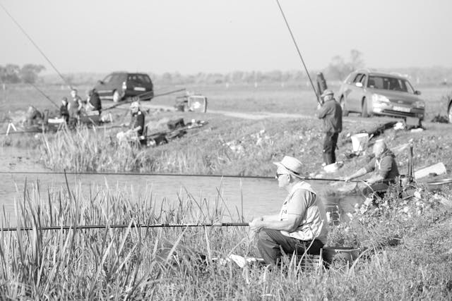A photo of people fishing by a lake.